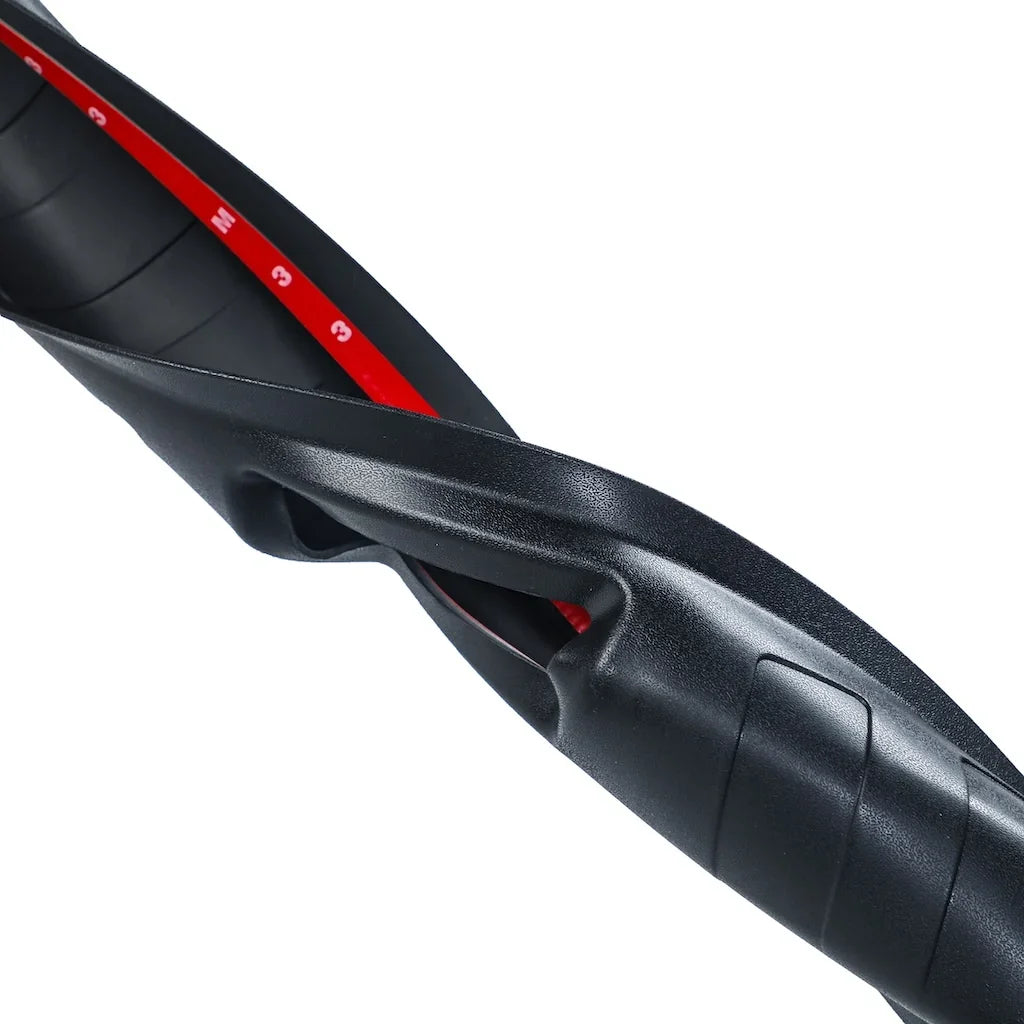 Close-up of a durable black textured rubber floor mat with a red measurement strip.