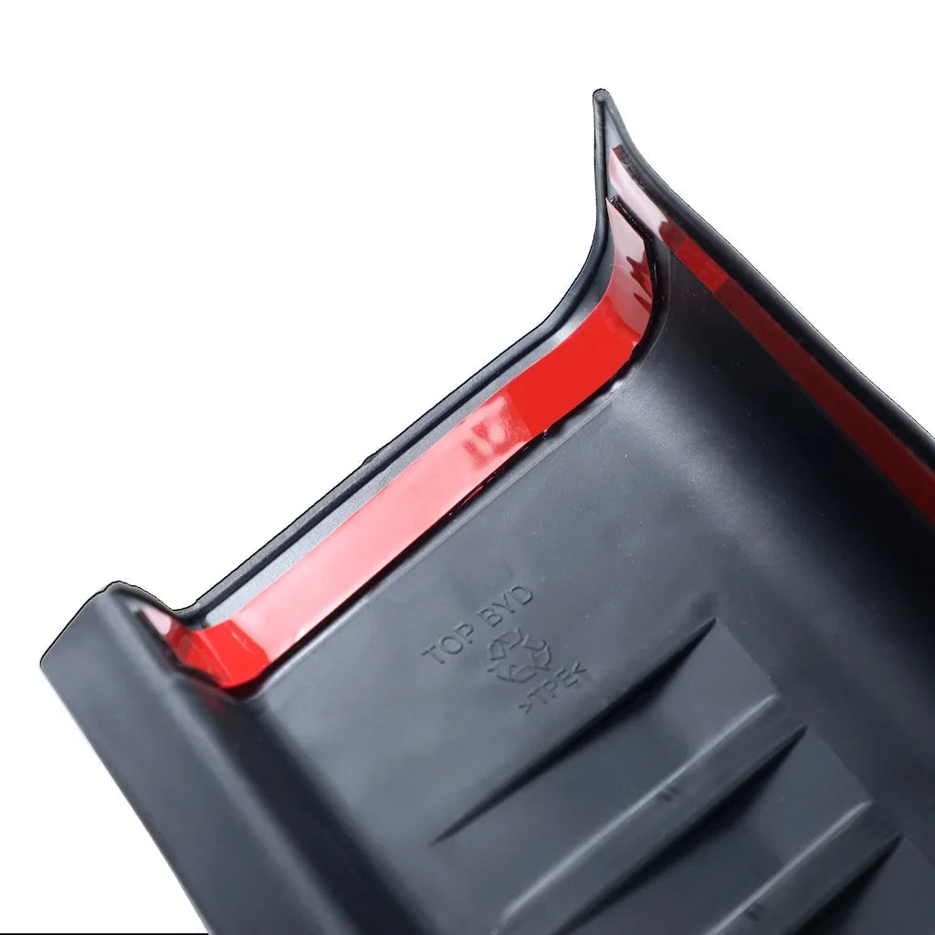 Close-up of a black TPE material car accessory with a red trim edge.