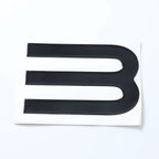 Black glossy emblem decal with three horizontal stripes on a white backing.