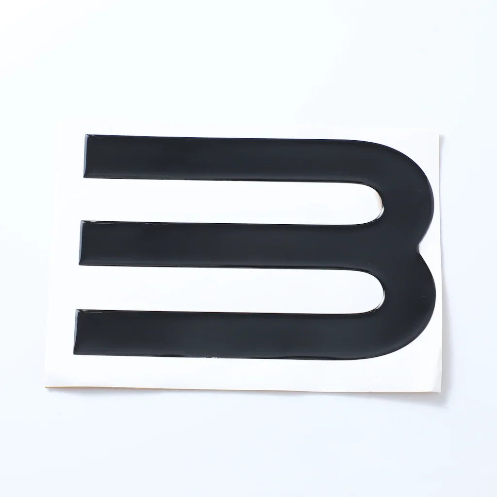 Black glossy emblem decal with three horizontal stripes on a white backing.