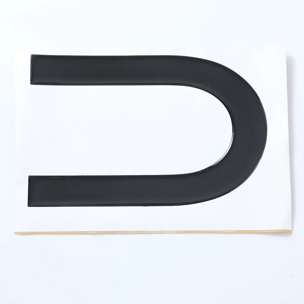 Black glossy U-shaped trim protector made of durable material for car body protection.