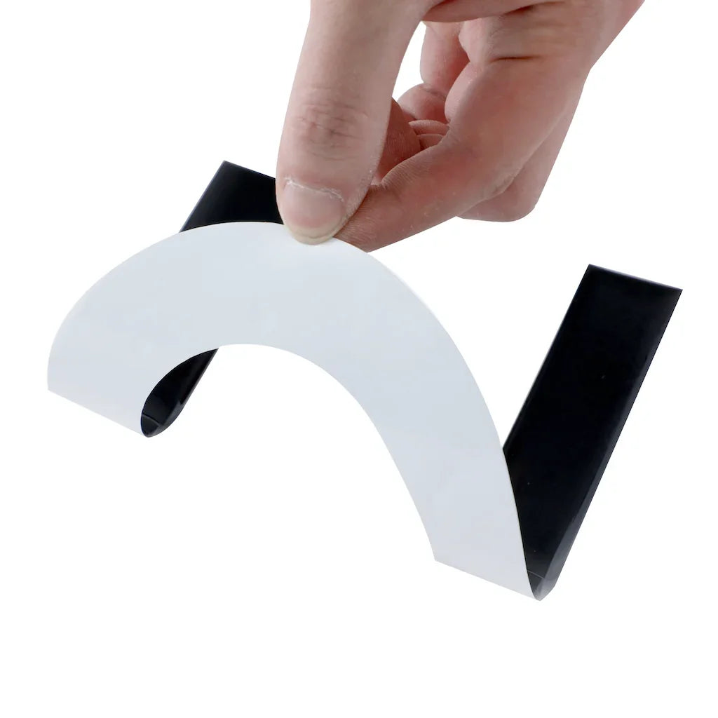 Hand peeling white protective film from a sleek black automotive trim accessory.