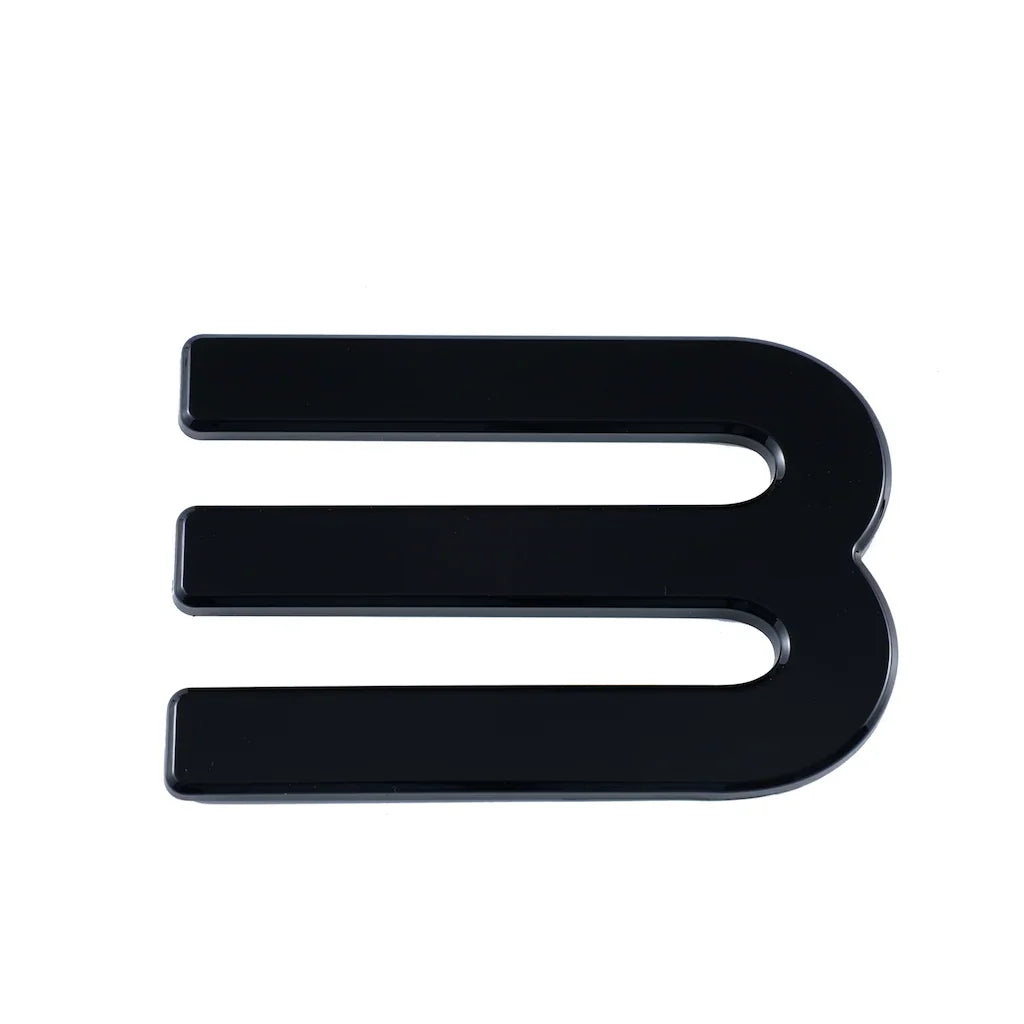 Glossy black E-shaped decorative emblem with a sleek, high-shine finish.