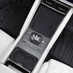 Black textured center console organizer and control panel in a white leather car interior.
