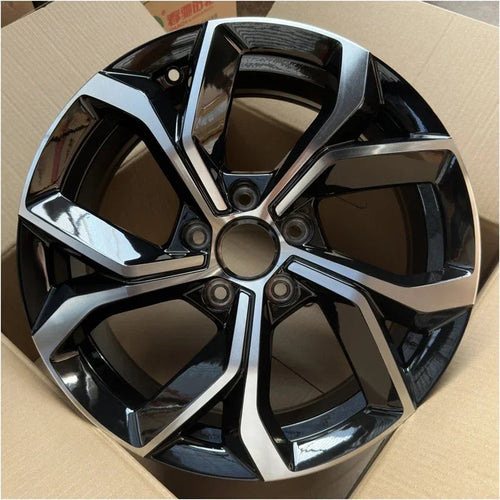 Glossy black and silver dual-tone alloy car wheel rim with a multi-spoke geometric design.