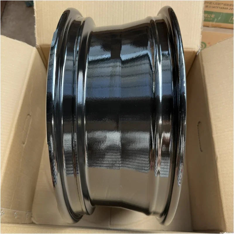 Glossy black steel car rim in a cardboard box, featuring a durable metallic finish.