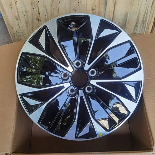 Black and silver dual-tone patterned car wheel hubcap with a glossy finish.