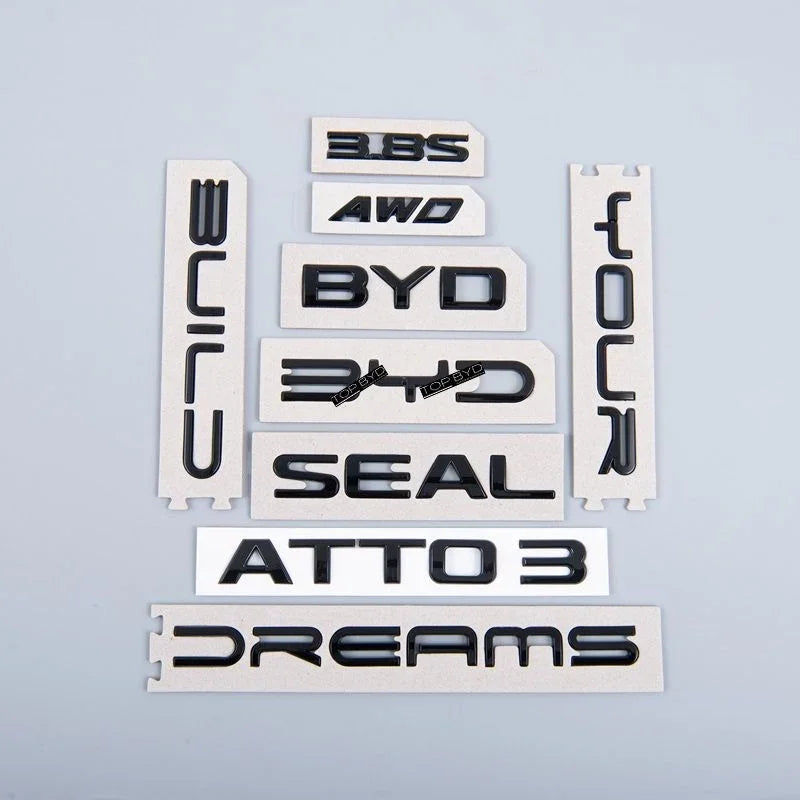 Glossy black 3D ABS plastic emblems for BYD Seal and Atto 3, including AWD and Dreams badges.