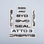 Glossy black 3D ABS plastic emblems for BYD Seal and Atto 3, including AWD and Dreams badges.