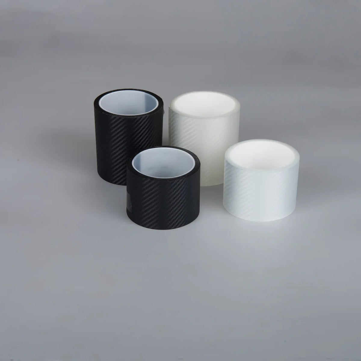 Three rolls of carbon fiber texture adhesive vinyl wrap in black and white colors.