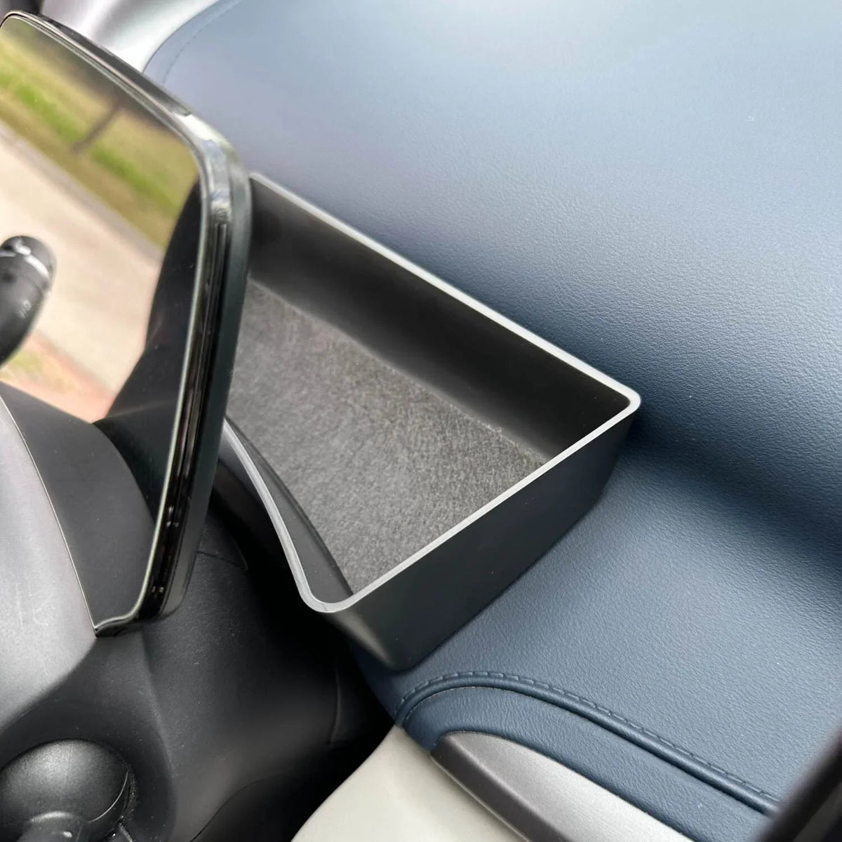 Black matte-finish interior organizer tray installed on a blue leather car console.