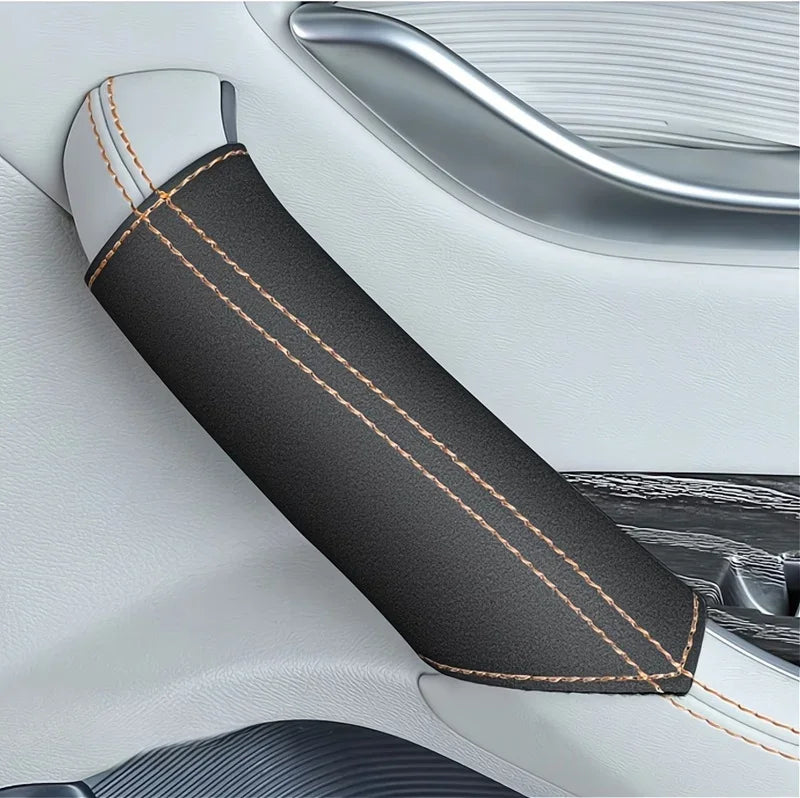 Black leather door handle protective cover with orange contrast stitching for car interior.
