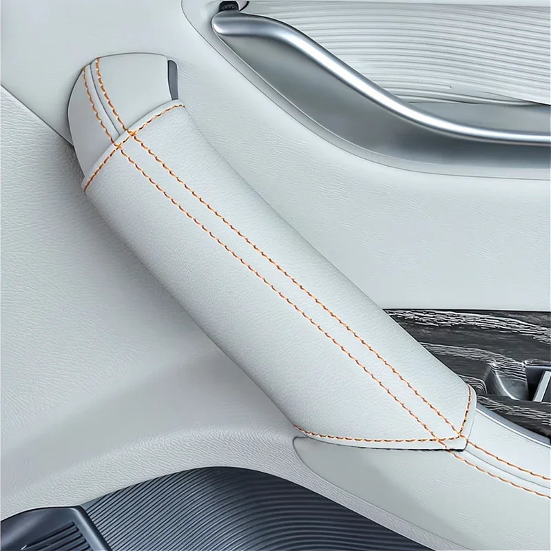 White leather car interior armrest cover with contrasting orange stitching.