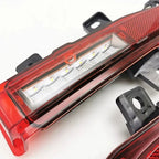 Close-up of a red translucent plastic car taillight with internal white LED lighting elements.