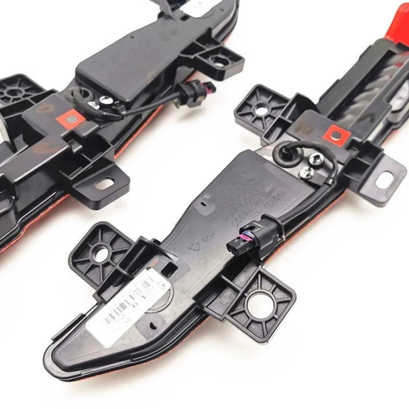 Black plastic door lock actuator assembly with red trim and electrical wiring components.