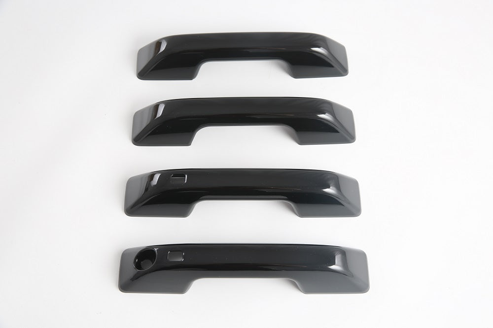 Set of four glossy black automotive door handle covers made of durable ABS material.