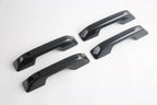 Four black carbon fiber textured car door handle covers for premium protection and style.