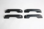 Set of four black carbon fiber texture car door handle covers for premium protection.