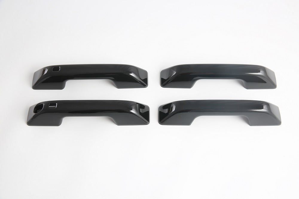 Set of four glossy black automotive door handles made of durable high-shine material.