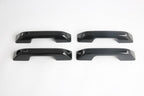 Set of four glossy black automotive door handles made of durable high-shine material.