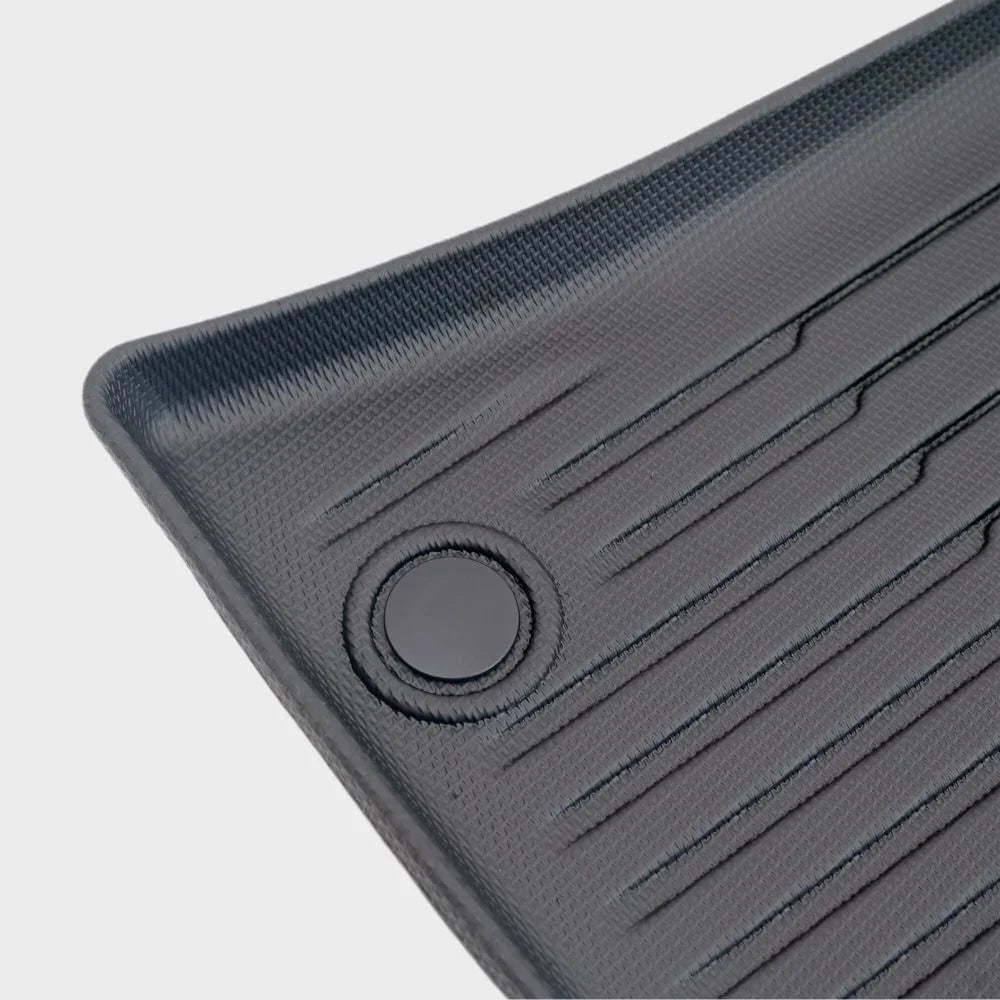 Close-up of a durable grey textured car floor mat with anti-slip ridges and reinforced grommet.