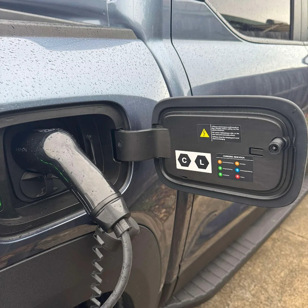 Close-up of a black electric vehicle charging plug inserted into a grey car's charging port.