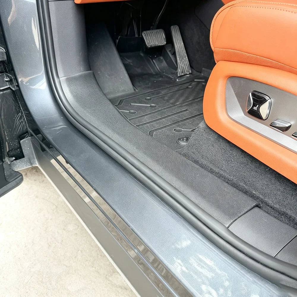 Custom-fit black heavy-duty rubber floor mats protecting the vehicle interior near tan leather seats.