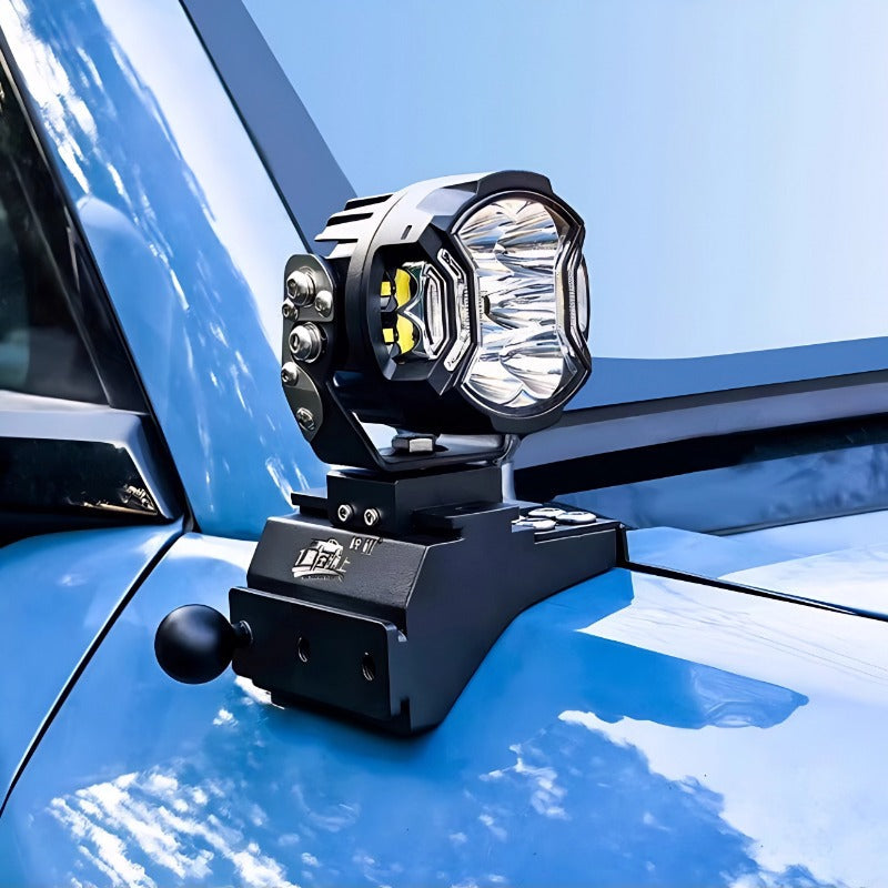 Black heavy-duty LED auxiliary driving light mounted on a blue vehicle hood.