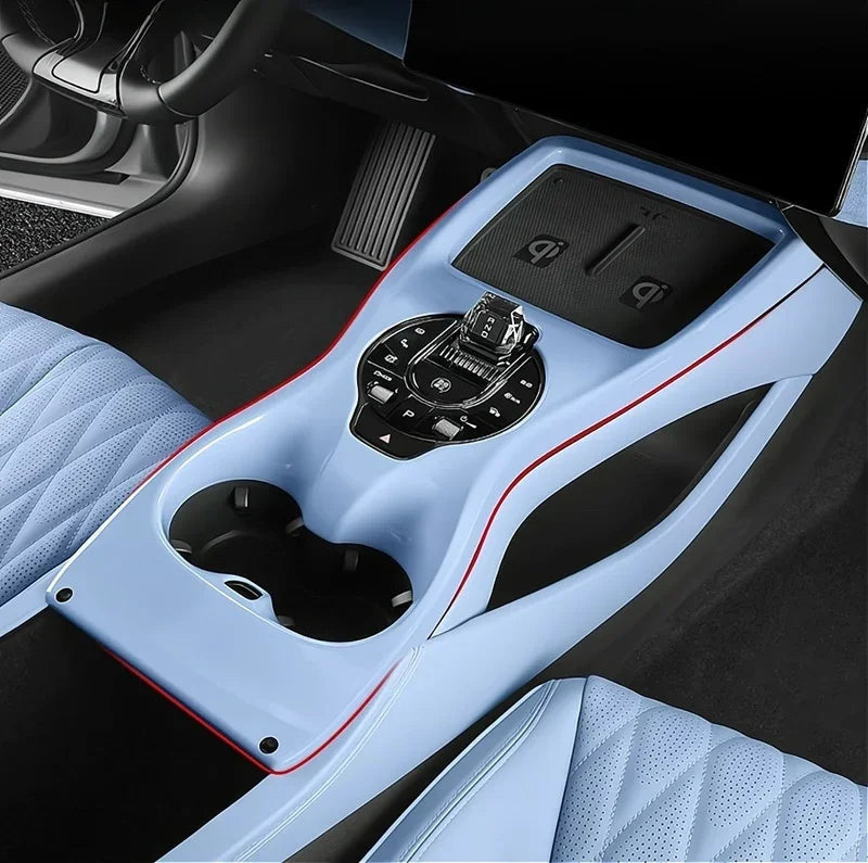 Light blue interior car console with custom-fit protective mats and sleek red trim accents.