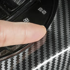 Black carbon fiber pattern protective film being applied to a car interior trim.