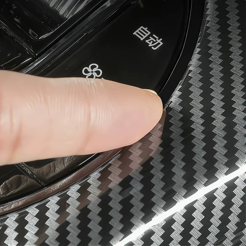 Black carbon fiber pattern protective film being applied to a car interior trim.