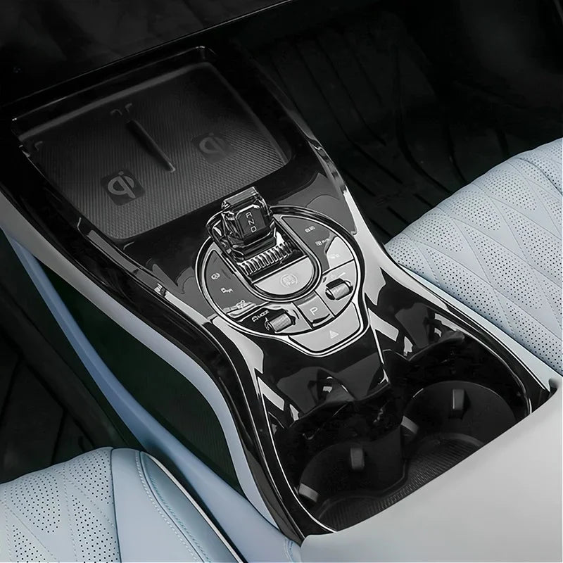Close-up of a sleek black and silver car center console featuring a gear shifter and cup holders.