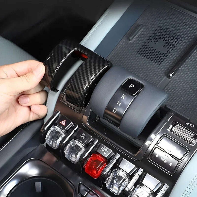 Carbon fiber texture gear shifter cover being installed in a car interior.