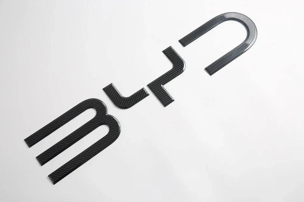 Black carbon fiber patterned BYD emblem badge for car exterior customization.