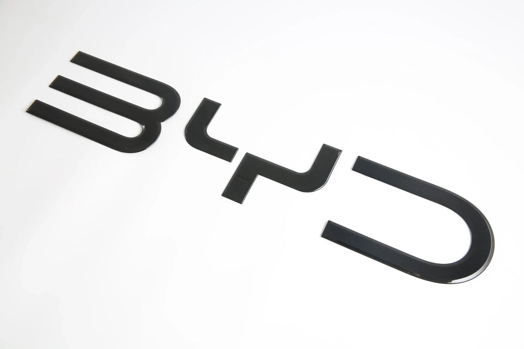 Glossy black BYD emblem badge made of premium high-shine material for car exterior decoration.