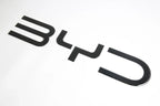 Glossy black BYD emblem badge made of premium high-shine material for car exterior decoration.