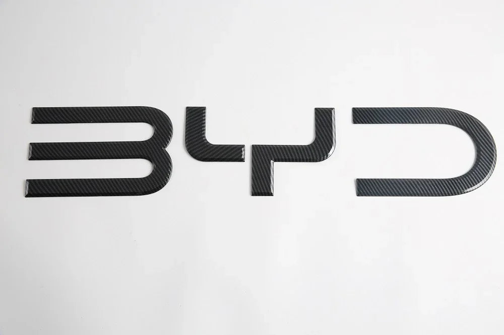 Black carbon fiber textured BYD emblem for car exterior decoration.