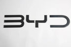 Black carbon fiber textured BYD emblem for car exterior decoration.