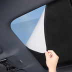 Black fabric car window sunshade with a white reflective coating for heat protection.
