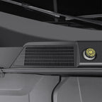 Black textured matte plastic vent cover with a yellow circular safety cap on a vehicle dashboard.