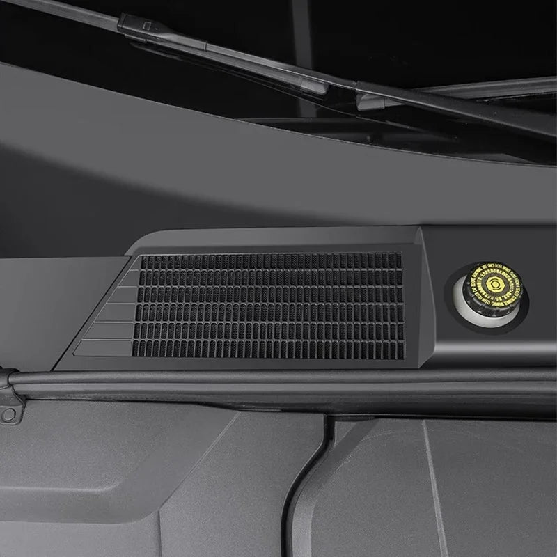 Black textured matte plastic vent cover with a yellow circular safety cap on a vehicle dashboard.