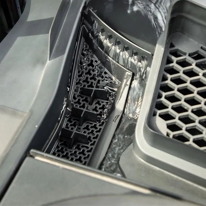 Close-up of grey TPE car floor mats featuring a waterproof hexagonal honeycomb texture.