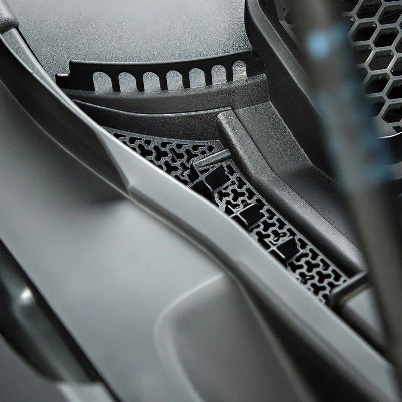 Black textured protective trim and honeycomb mesh vent for vehicle interior protection.