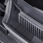 Close-up of a black durable plastic car organizer tray with integrated drainage grilles.