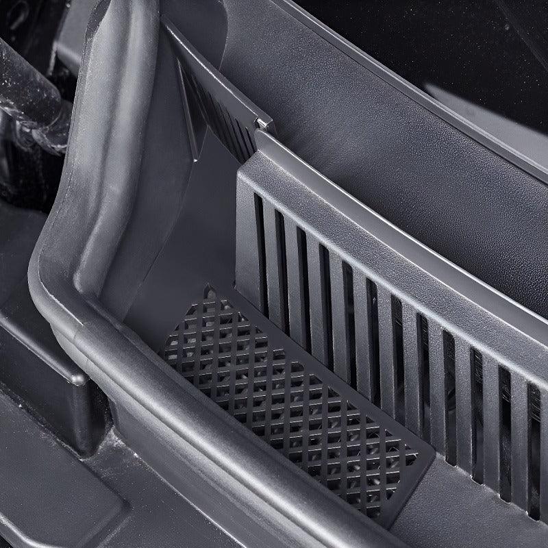 Close-up of a black durable plastic car organizer tray with integrated drainage grilles.
