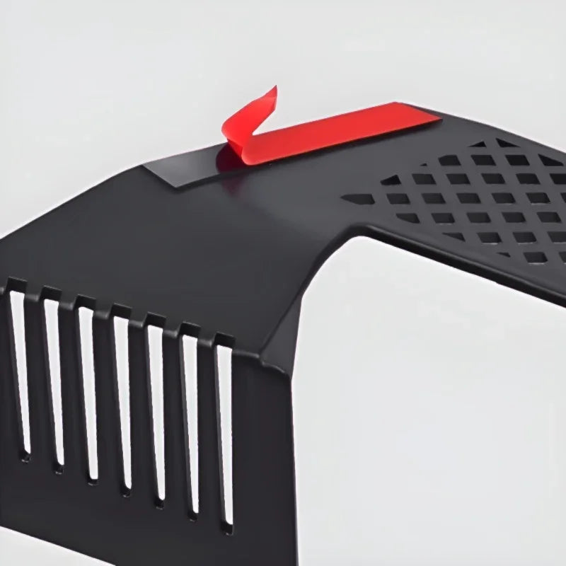 Close-up of a black matte metal car accessory featuring a red adhesive strip.
