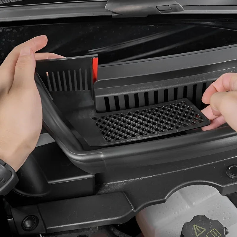 Hands installing a black matte ABS plastic cowl cover on a car engine bay.