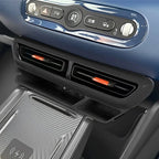 Black carbon fiber texture center console with dual air vents and orange accent sliders.
