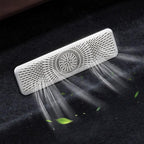 Silver metallic car air vent cover with fine perforated pattern emitting refreshing air flow.