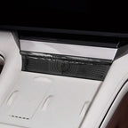 Close-up of a sleek black patterned console trim piece installed in a white luxury car interior.